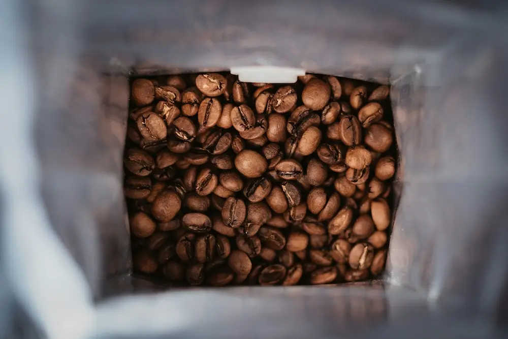 Kaffepose fyldt med friskristede kaffebønner fra the Artisan